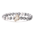 Close-up of dolphin-shaped bead and textured white stone beads on a stretch bracelet - White Howlite Bracelet