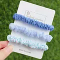 Détail de chouchous en tissu bleu sur carte de présentation avec fond d'herbe naturelle - 3 pièces Bleu Vibrant