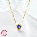 Macro detail of S925 sterling silver gold-plated necklace with sparkling blue zircon pendant - 925 Silver / Gold Blue