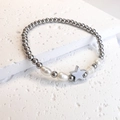 Detail of beaded bracelet with silver beads, baroque pearls and star charm on rock - Pentagram / Steel