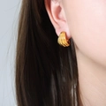 U-shaped 18K gold plated hoop earrings with vertical ribbed texture on model - Gold