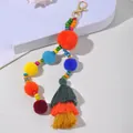 Dettaglio portachiavi boho con pompon colorati, nappe e perline in legno - Rosso Arancio