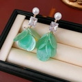Dettaglio di orecchini con petali di conchiglia verde, zirconi e perle bianche - Verde