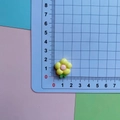Detailed scale view of 1.8cm resin plumeria charm with yellow petals and pink center - Yellow