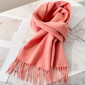 Soft coral pink wool scarf with fringe detail on white marble surface - Peach Pink