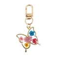 Detalle de llavero de mariposa en resina con flores secas de colores y borde dorado - Mariposa De Flor Amarilla