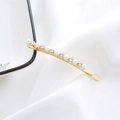 Detailed shot of golden hair clip inlaid with white pearls and sparkling rhinestones - Arched Pearl Rhinestone Bobby Pin