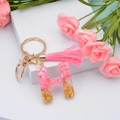 Pink resin letter H keychain with gold foil flakes and a soft matching tassel charm - Letter H