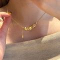 Elegante goldene Münzkette im Retro-Stil an einer Frau bei sanftem natürlichem Licht - Halskette / Gold