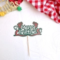 Close-up of Merry Christmas paper cake topper with green background and wooden stick - Style N Merry Christmas