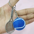 Detail shot of mini silver tennis racket and blue felt ball keychain on pink background - 3.8cm Ball / Blue