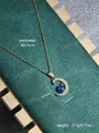 Detail van gouden maan hanger met blauwe glitter bol en zirkonia op groene getextureerde stof - Goud (KS-33-Goud)