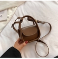 Detailed macro view of a dark brown mini crossbody bag held in hand for scale - Brown