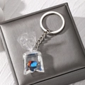 Macro detail of tropical fish resin keychain featuring a clear water bag pendant - Red Blue Fish