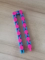Pink and blue wacky tracks snap and click fidget toy chain on wooden surface - Rose Red And Blue