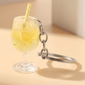 Macro view of luminous yellow lemon drink keychain with straw in clear plastic goblet - Yellow