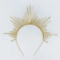 Dettaglio della corona a raggiera dorata con punte metalliche e cristalli incastonati - Stile Zirconia / Oro