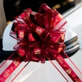 Close-up of burgundy wedding car bow with gold double joy character on a mirror - 10 Strands Pack / Double Joy Wine Red