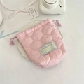Close-up of pink quilted drawstring storage pouch with cloud texture on ceramic tray - Gourd Pattern Light Pink