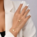 Detailed view of a gold finger bracelet featuring butterfly and star charms on a model hand - Butterfly Pentagram Style (TZ0126)