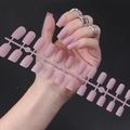 Detail of matte mauve square fake nails showing various sizes and worn on a hand - Matte Pink Purple