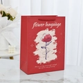 Elegant red gift bag with rose illustration and woven handles on marble surface - Flower Language - Rose Love