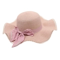 Détail d'un chapeau de paille rose avec bord ondulé et nœud satiné perlé - Taille unique / Rose