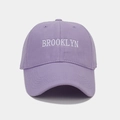 Close-up of white Brooklyn letter embroidery on a lavender cotton baseball cap - Light Purple
