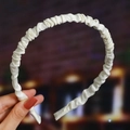 Detailed view of a white pleated satin headband featuring a wavy texture and smooth finish - White (Satin Pleated)