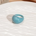 Detailed view of blue marble resin ring on a textured white ceramic decorative plate - Blue Oval