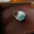 Detalle macro de anillo con gema verde esmeralda y pétalos de cristal fino - Anillo Abierto de Diamantes de Imitación Verdes
