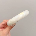 Detailed view of the pearlescent white shell spring hair clip with glossy texture - Mermaid White