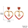 Elegant gold heart earrings with red enamel and clear cubic zirconia on white background - Red