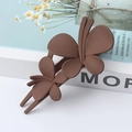 Elegant large matte brown butterfly hair clip on a white book with decorative flowers - Coffee