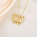Macro shot of 3D balloon-style letter W pendant with colorful zircons and gold chain - Letter W