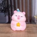 Tirelire capybara rose avec chapeau de Noël bleu et accessoire d'étoile jaune - Grand Capybara Rose B Tenant une Étoile