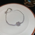 Dettaglio del bracciale con fiori in zircone scintillante su un piatto di porcellana - Quadrifoglio (HB3490) / Argento