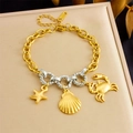 Detail of gold chain bracelet featuring relief starfish shell and crab charms on display - Marine Starfish Crab Style (B1662)
