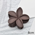 Detailed top view of 8cm brown plumeria hair claw clip with matte finish on rock surface - Dark Brown Matte 8cm
