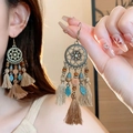 Détail de boucles d'oreilles bohèmes vintage avec disque floral en bronze et glands beige - Style 20 Crochet Or Café Fleur