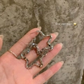 Star shaped silver stud earrings with geometric metal cubes held by model - Pentagram Geometric (A2589 Silver)