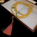 Dettaglio collana di perline gialle con lunga nappa rossa e accenti verdi - Collana Gialla Con Nappa Rossa