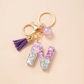 Letter N resin keychain with purple glitter, suede tassel, and golden metal clasp - Letter N