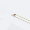 Minimalist gold necklace featuring a black cube pendant with the golden letter O - Letter O