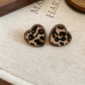 Close-up of heart-shaped leopard print earrings with brown borders on beige fabric - 20# Heart Shape Leopard Fabric Studs (Silver Earring Post-Heart-Coffee)