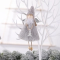 Gray plush Christmas angel ornament with sequin wings hanging on a winter tree display - Christmas Tree / Gray