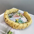 Detailed view of yellow satin pleated headband with elegant twisted silk texture - Bright Yellow