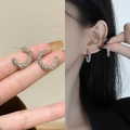 Detail of silver C-shape hoop earrings with a frosted texture shown on a model - Silver Frosted C-Shape Style (E2189 Silver) / 925 Silver Needle / Silver