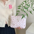 Detalle de neceser acolchado rosa con motivos de conejos y corazones sostenido a mano - Bebé Oso Corazón Acolchado