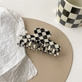 Detail of a large black and white checkerboard hair claw clip with a glossy finish - Keel Style Claw
